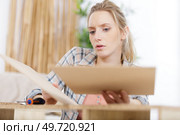 assembling drawer bedside table the woman mounts the boards together. Стоковое фото, агентство Ingram Publishing / Фотобанк Лори