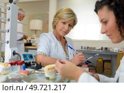 woman with clipboard observing trainee working with prosthetics. Стоковое фото, агентство Ingram Publishing / Фотобанк Лори