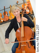 woman plays the cello in a store. Стоковое фото, агентство Ingram Publishing / Фотобанк Лори
