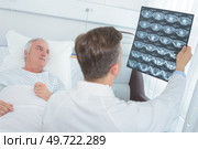 doctors checking patients xray in hospital room. Стоковое фото, агентство Ingram Publishing / Фотобанк Лори