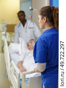 patient hospital bed moved by medical staff to operating room. Стоковое фото, агентство Ingram Publishing / Фотобанк Лори