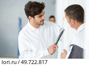 portrait of apprentice scraping wall edge. Стоковое фото, агентство Ingram Publishing / Фотобанк Лори