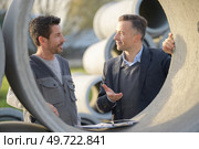 manager and worker next to concrete drainage pipe. Стоковое фото, агентство Ingram Publishing / Фотобанк Лори