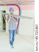 shot of a builder carrying metal joists. Стоковое фото, агентство Ingram Publishing / Фотобанк Лори