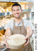 Shop assistant holding a tomme cheese. Стоковое фото, агентство Ingram Publishing / Фотобанк Лори