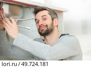 portrait of plumber fixing a sink. Стоковое фото, агентство Ingram Publishing / Фотобанк Лори