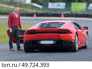 man on moto show trying a car. Стоковое фото, агентство Ingram Publishing / Фотобанк Лори