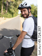 handsome young man biking in the countryside. Стоковое фото, агентство Ingram Publishing / Фотобанк Лори