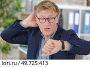 man looking at wrist-watch touching his head being late. Стоковое фото, агентство Ingram Publishing / Фотобанк Лори
