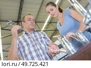 Man and woman looking at taps. Стоковое фото, агентство Ingram Publishing / Фотобанк Лори
