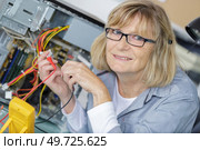 mature female technician during voltage measurement. Стоковое фото, агентство Ingram Publishing / Фотобанк Лори