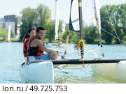 young couple on small catamaran sailboat. Стоковое фото, агентство Ingram Publishing / Фотобанк Лори