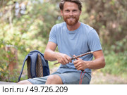 young tourist cutting wood in nature. Стоковое фото, агентство Ingram Publishing / Фотобанк Лори
