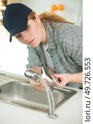 a woman fixing kitchen sink. Стоковое фото, агентство Ingram Publishing / Фотобанк Лори