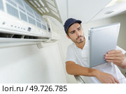 young contractor working carefully and seriously at clients office. Стоковое фото, агентство Ingram Publishing / Фотобанк Лори