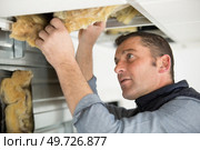 man repairing collapsed ceiling at site. Стоковое фото, агентство Ingram Publishing / Фотобанк Лори