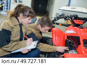 the young mechanics examining quadbike. Стоковое фото, агентство Ingram Publishing / Фотобанк Лори