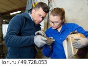 workers inspecting metal woman holding visor. Стоковое фото, агентство Ingram Publishing / Фотобанк Лори