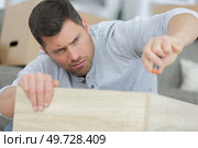 man on complicated assembling mission. Стоковое фото, агентство Ingram Publishing / Фотобанк Лори