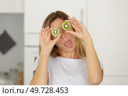 woman doing a joke with sliced kiwi on her eyes. Стоковое фото, агентство Ingram Publishing / Фотобанк Лори