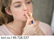 woman uses a lighter to light cigarette. Стоковое фото, агентство Ingram Publishing / Фотобанк Лори