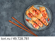 Enoki or enokitake mushroom roasted in bacon on plate. Bacon wrapped mushroom. Flat lay with copy space.. Enoki mushrooms rolls, space for text. Стоковое фото, агентство Ingram Publishing / Фотобанк Лори