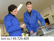 the factory operatives using scales. Стоковое фото, агентство Ingram Publishing / Фотобанк Лори
