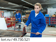 Lady holding copper pipe in vice. Стоковое фото, агентство Ingram Publishing / Фотобанк Лори