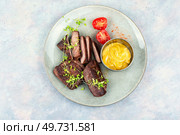 Roasted ostrich steaks with sauce on a plate. African food. Top view.. Fried tasty ostrich steaks. Стоковое фото, агентство Ingram Publishing / Фотобанк Лори