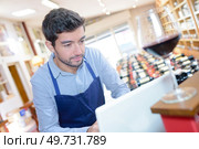 handsome sommelier ordering wine on computer at store. Стоковое фото, агентство Ingram Publishing / Фотобанк Лори