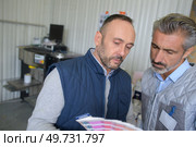 Men looking at paint colour charts. Стоковое фото, агентство Ingram Publishing / Фотобанк Лори
