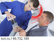 male apprentice setting up ventilation system indoors. Стоковое фото, агентство Ingram Publishing / Фотобанк Лори