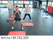 gym people doing squats during fitness classes. Стоковое фото, агентство Ingram Publishing / Фотобанк Лори