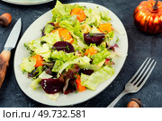 Autumn salad of baked pumpkin, beetroot and greens in a plate on the table. Healthy eating. Autumn salad with pumpkin and beets. Стоковое фото, агентство Ingram Publishing / Фотобанк Лори