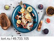 Whole grilled or baked whole dorado fish with lemon, almonds and figs. Autumn recipe.. Tasty roasted dorado or gilt head bream fish. Стоковое фото, агентство Ingram Publishing / Фотобанк Лори