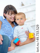 happy mother with baby lying on bed at home. Стоковое фото, агентство Ingram Publishing / Фотобанк Лори
