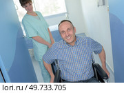 nurse pushing a patients wheelchair. Стоковое фото, агентство Ingram Publishing / Фотобанк Лори