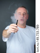a man smoking an e cigarette. Стоковое фото, агентство Ingram Publishing / Фотобанк Лори