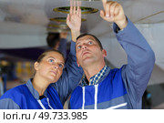 male and female engineers inspecting underside of aircraft fuselage. Стоковое фото, агентство Ingram Publishing / Фотобанк Лори