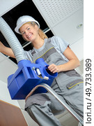 happy female electrician fitting a cable for ceiling light. Стоковое фото, агентство Ingram Publishing / Фотобанк Лори