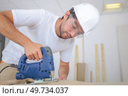 man cutting wood block with fretsaw at the workshop. Стоковое фото, агентство Ingram Publishing / Фотобанк Лори