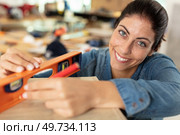 female carpenter putting spirit level on wood. Стоковое фото, агентство Ingram Publishing / Фотобанк Лори
