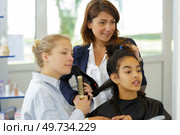 portrait of an apprentice hairdresser at work. Стоковое фото, агентство Ingram Publishing / Фотобанк Лори