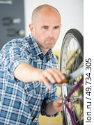 a man adjusting the bikes chains. Стоковое фото, агентство Ingram Publishing / Фотобанк Лори