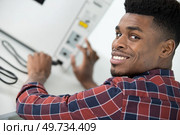 young man plugging power cable into a computer. Стоковое фото, агентство Ingram Publishing / Фотобанк Лори