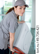 young happy woman carrying washer in kitchen. Стоковое фото, агентство Ingram Publishing / Фотобанк Лори