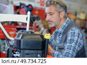 portrait of mechanic working on lawnmower. Стоковое фото, агентство Ingram Publishing / Фотобанк Лори