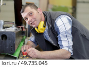 a worker with noise cancelling looking at camera. Стоковое фото, агентство Ingram Publishing / Фотобанк Лори