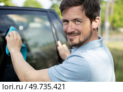 happy man worker washing windshield with sponge. Стоковое фото, агентство Ingram Publishing / Фотобанк Лори