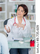 sick woman complaining to doctor about symptoms of malaise. Стоковое фото, агентство Ingram Publishing / Фотобанк Лори